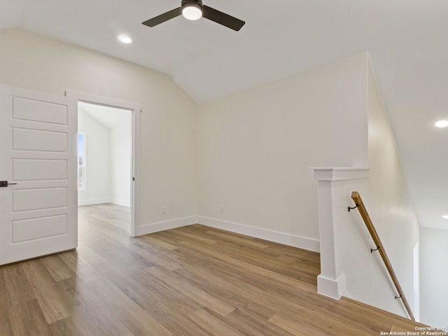 spare room featuring ceiling fan, lofted ceiling, and light hardwood / wood-style flooring