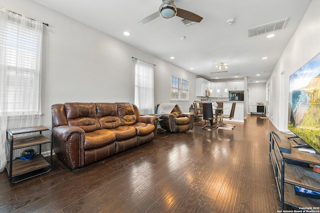 living room with ceiling fan and dark hardwood / wood-style floors