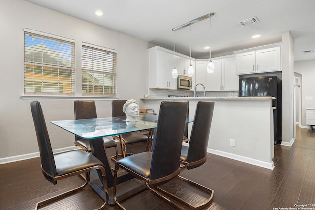 dining space with dark hardwood / wood-style floors and sink