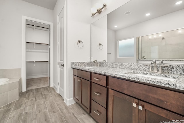 bathroom featuring vanity and shower with separate bathtub