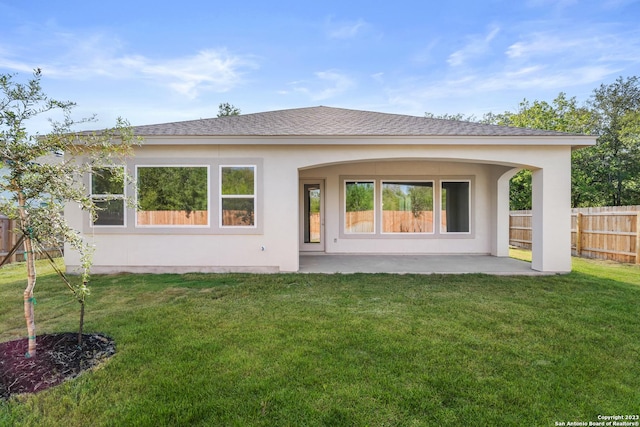 back of house featuring a patio and a lawn