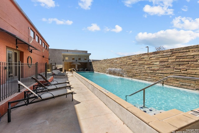 view of swimming pool with pool water feature and a patio area