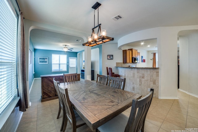 tiled dining space with ceiling fan