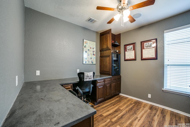 home office with dark wood-type flooring and ceiling fan