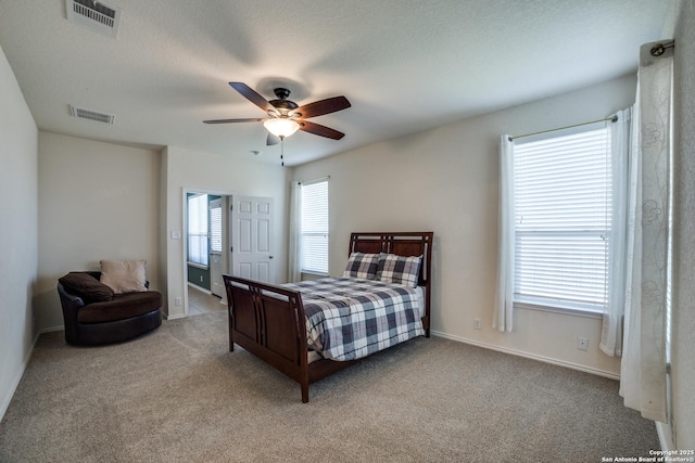 bedroom featuring light carpet, a textured ceiling, and ceiling fan