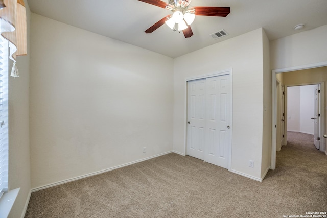 unfurnished bedroom featuring ceiling fan, a closet, and light carpet