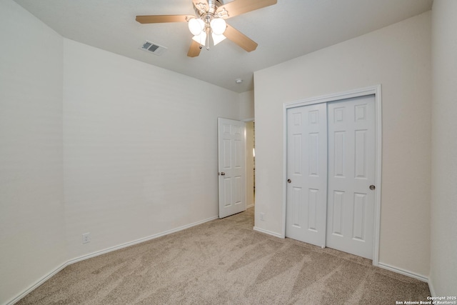 unfurnished bedroom with ceiling fan, light colored carpet, and a closet