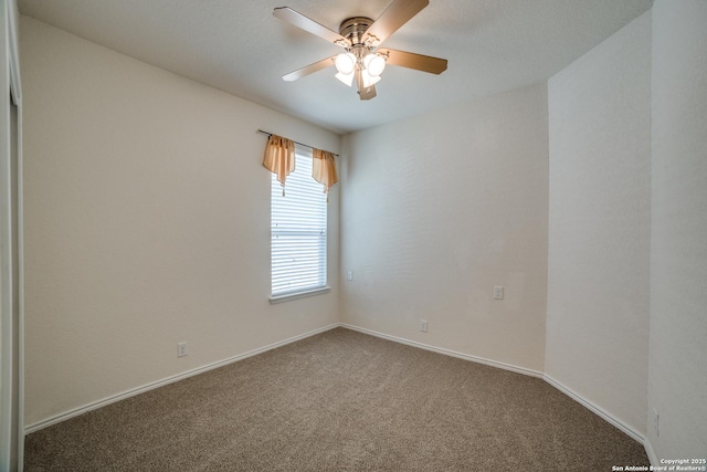 empty room featuring ceiling fan and carpet