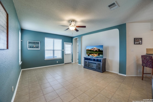 unfurnished living room featuring light tile patterned flooring, a textured ceiling, and ceiling fan