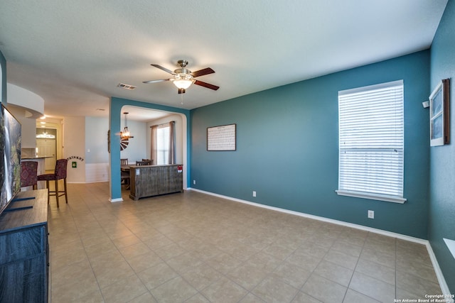 empty room featuring ceiling fan with notable chandelier