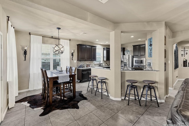 dining area featuring a notable chandelier and light tile patterned floors