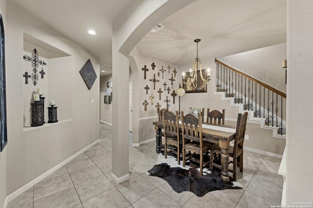 tiled dining area featuring a chandelier