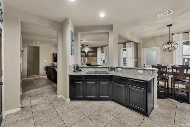 kitchen featuring light stone counters, hanging light fixtures, a chandelier, and light tile patterned flooring