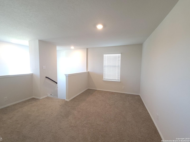 carpeted spare room featuring plenty of natural light and a textured ceiling