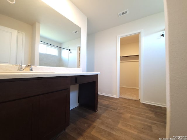 bathroom featuring walk in shower, wood-type flooring, and vanity