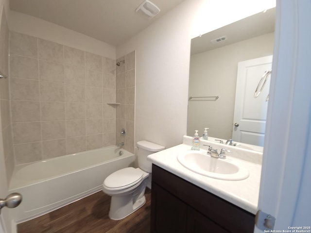 full bathroom featuring tiled shower / bath, wood-type flooring, vanity, and toilet