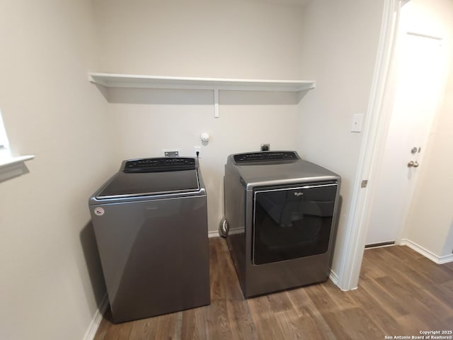 washroom featuring dark hardwood / wood-style flooring and washing machine and dryer