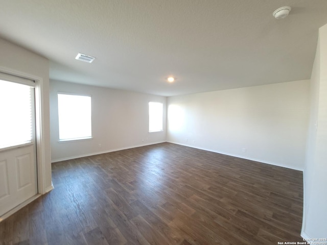 empty room with dark hardwood / wood-style flooring