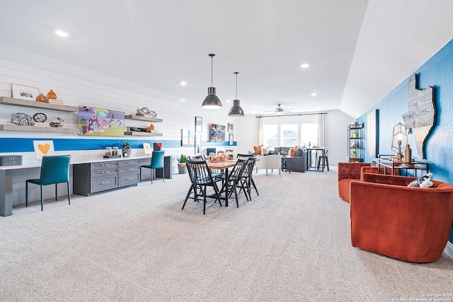 dining room featuring vaulted ceiling, light colored carpet, a ceiling fan, and built in study area