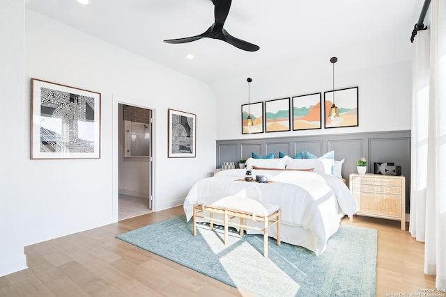 bedroom featuring lofted ceiling, connected bathroom, recessed lighting, baseboards, and light wood-style floors