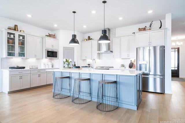 kitchen featuring stainless steel fridge with ice dispenser, glass insert cabinets, light countertops, black microwave, and pendant lighting