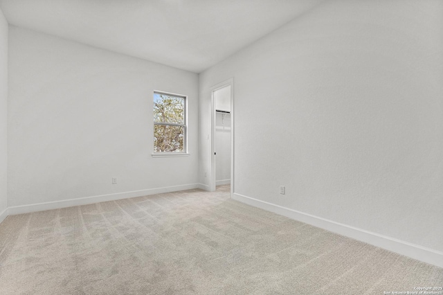 unfurnished room with light carpet and baseboards