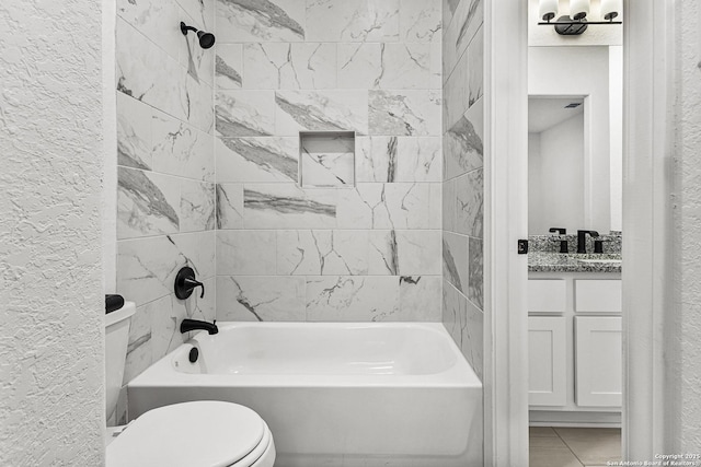 bathroom featuring a textured wall, shower / bath combination, and vanity