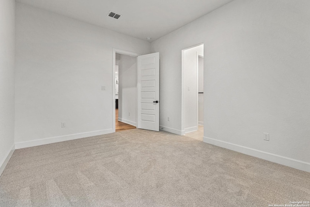 unfurnished bedroom featuring baseboards, visible vents, and light colored carpet