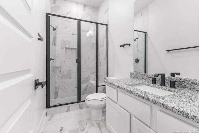 bathroom with marble finish floor, toilet, vanity, and a marble finish shower