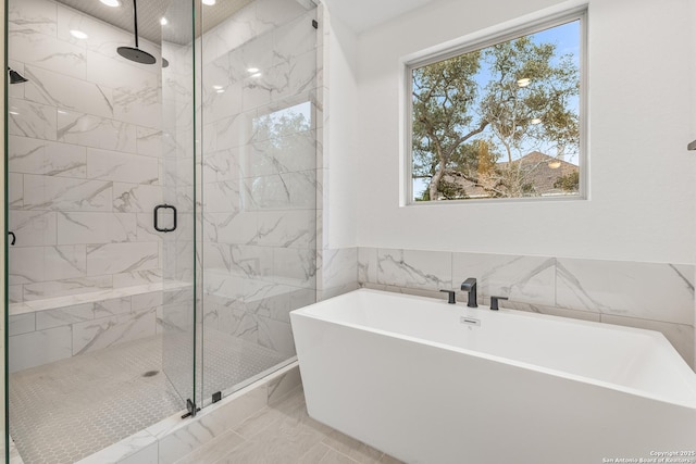 bathroom featuring a freestanding tub, marble finish floor, and a marble finish shower