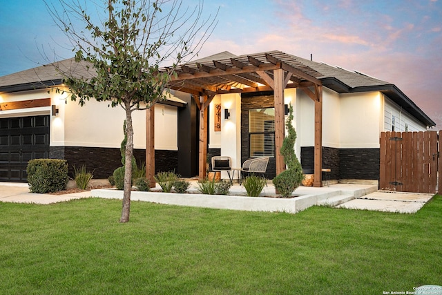 view of front of home featuring a pergola, a garage, and a lawn