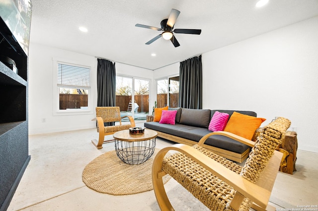 living room with ceiling fan and a textured ceiling