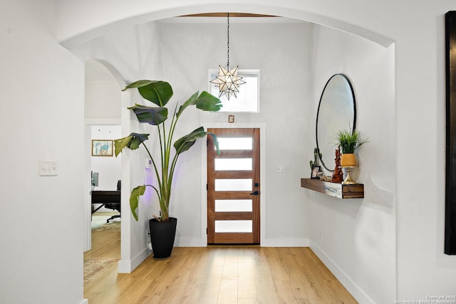 foyer entrance with hardwood / wood-style flooring and a notable chandelier