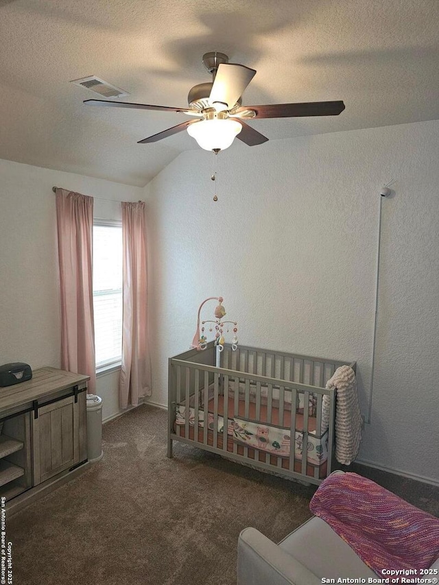 bedroom with dark carpet, a textured ceiling, and ceiling fan