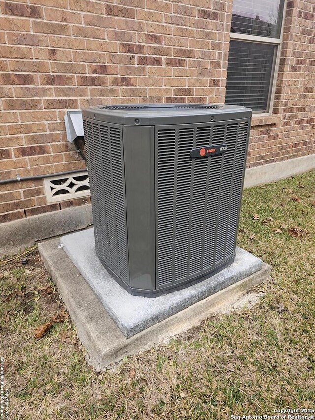 exterior details featuring brick siding and central AC unit