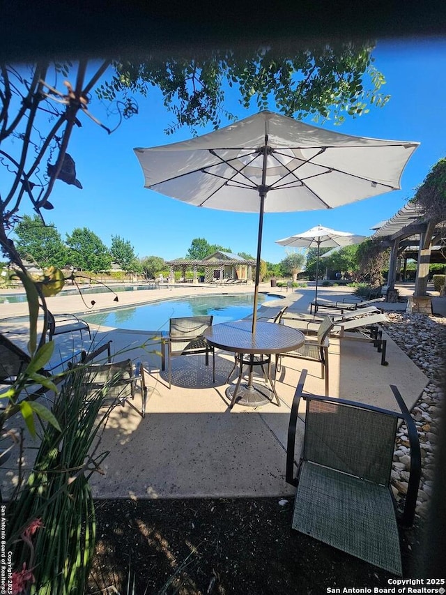 pool featuring a pergola and a patio area