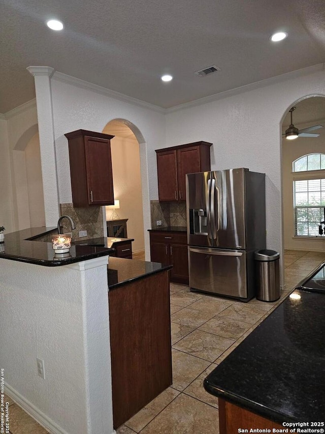 kitchen featuring crown molding, kitchen peninsula, stainless steel fridge with ice dispenser, and tasteful backsplash