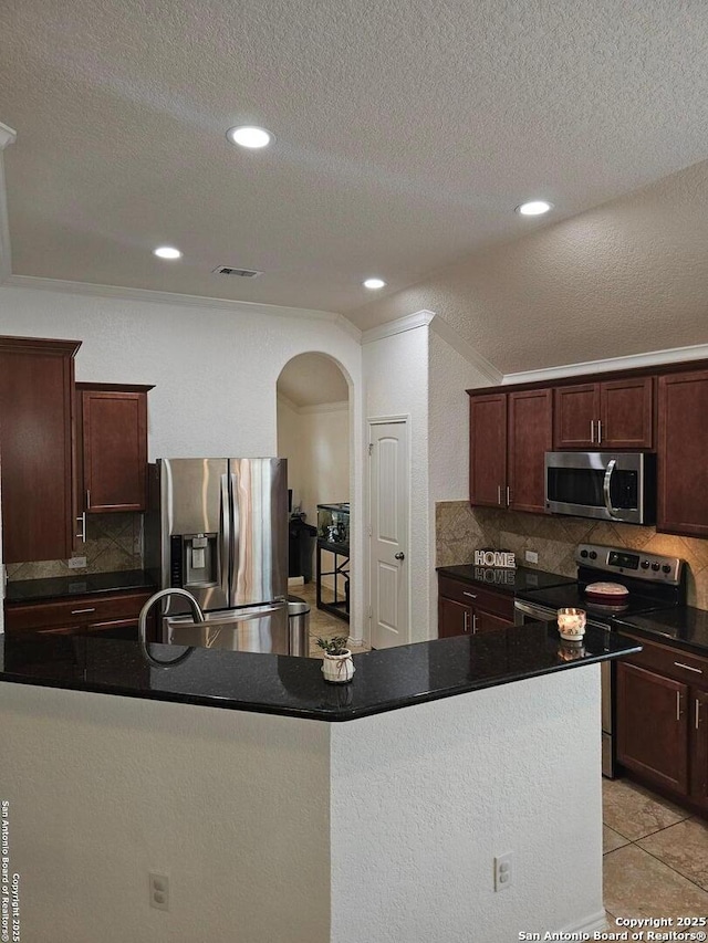 kitchen with tasteful backsplash, light tile patterned floors, dark brown cabinetry, stainless steel appliances, and a textured ceiling