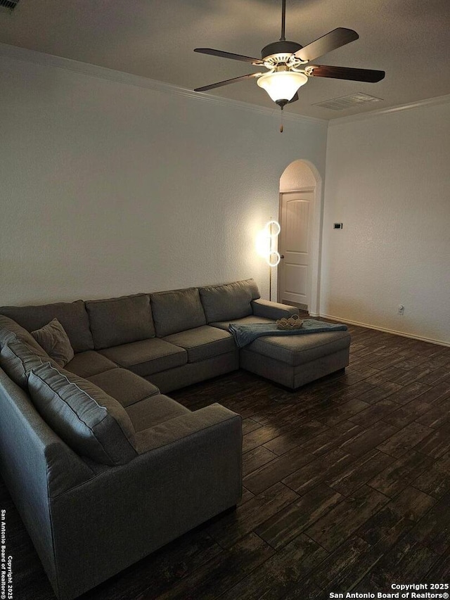 living room featuring crown molding, dark wood-type flooring, and ceiling fan