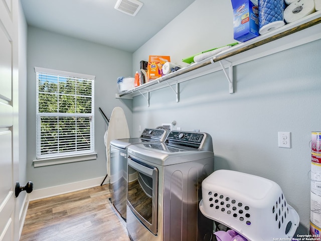 laundry room with separate washer and dryer and light wood-type flooring