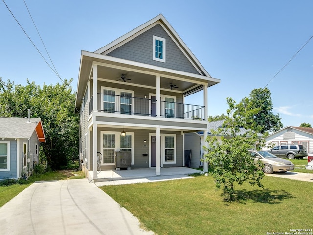 view of front of property with ceiling fan, a balcony, covered porch, and a front yard