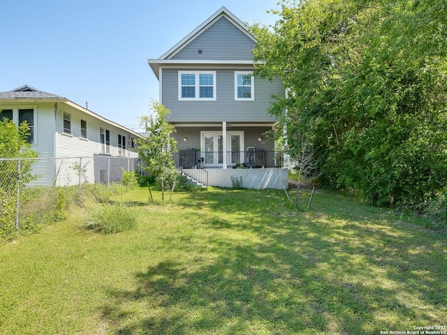 rear view of house featuring a lawn