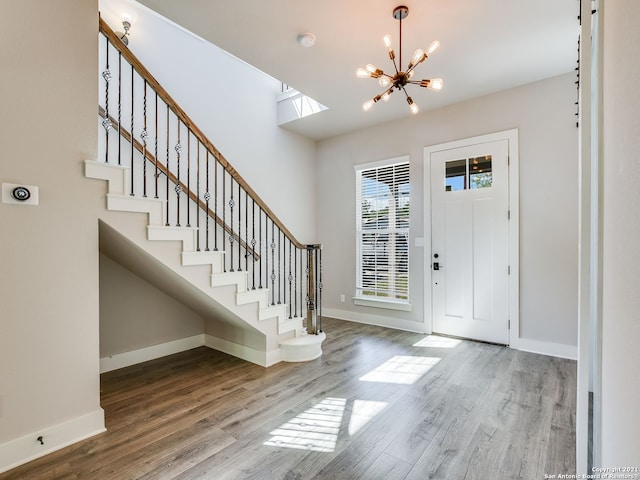 foyer entrance with a notable chandelier and hardwood / wood-style flooring