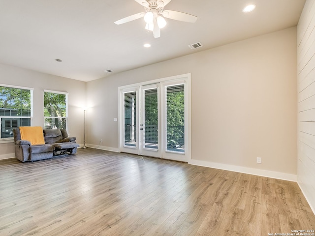 living area featuring light hardwood / wood-style floors and ceiling fan