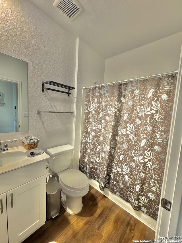 bathroom featuring vanity, wood-type flooring, and toilet