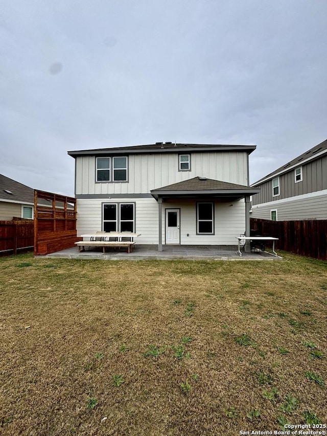 back of property with a lawn and a patio