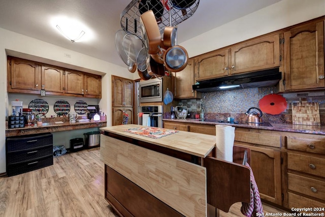 kitchen featuring decorative backsplash, light hardwood / wood-style floors, and appliances with stainless steel finishes