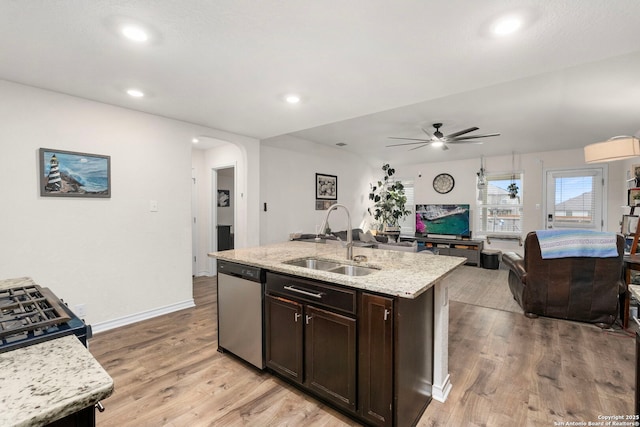 kitchen with dark brown cabinetry, sink, light stone counters, dishwasher, and a kitchen island with sink