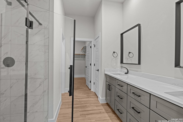 bathroom featuring walk in shower, vanity, and wood-type flooring