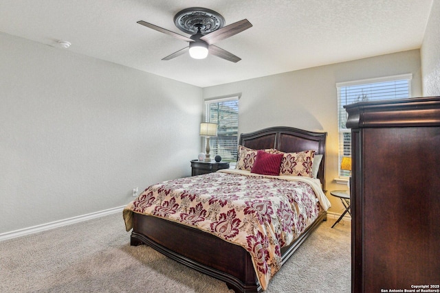 carpeted bedroom featuring a textured ceiling and ceiling fan